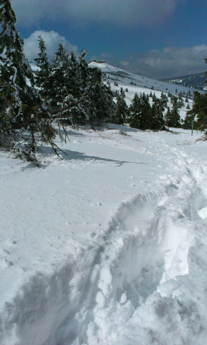 Vzadu Petráky. Sněhu skoro po kolena. Místy v těch svých teniskách šlapu stopu.