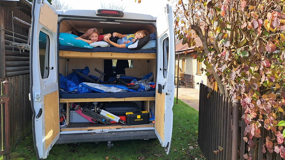 Příjezd - dole věci, uprostřed kolo, nahoře děti